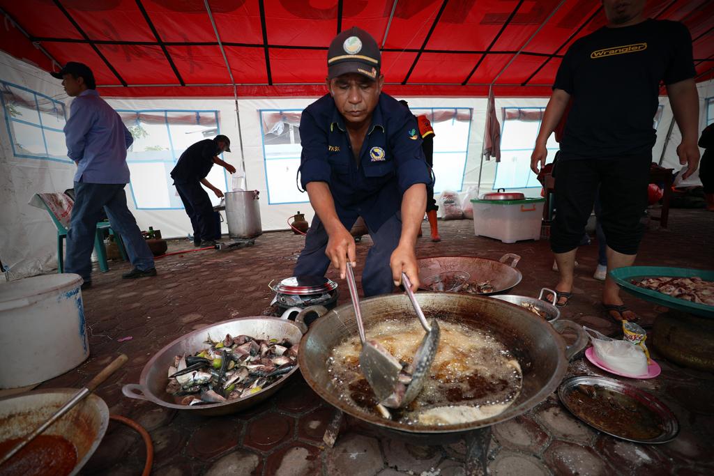 Petugas memasak lauk pauk untuk dibagikan kepada pengungsi banjir bandang di Kantor Kecamatan Baktiraja, Kabupaten Humbang Hasundutan, Sumatera Utara, Selasa (5/12).